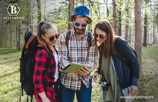 Guía con dos excursionistas mirando un mapa en un claro de un bosque