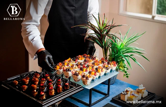 Empleado de una agencia de catering acomodando dos bandejas de refrigerios