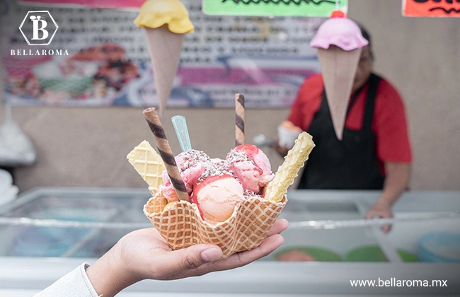 Mano sosteniendo una porción de helados de distintos sabores